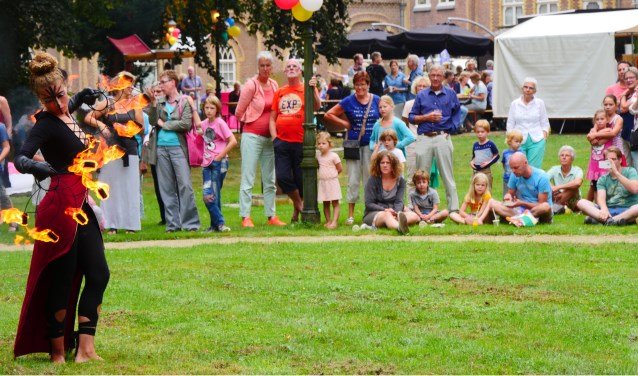 Toeschouwers kijken vol bewondering naar een jongleuse met vuur tijdens Kunstival van vorig jaar.