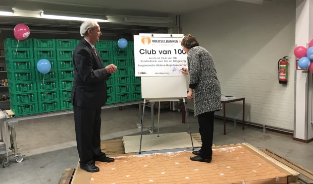Burgemeester Wobine Buijs van Oss tekent als eerste lid van de Club van 100 van de Voedselbank voor Oss en Omgeving haar overeenkomst. Links haar voorganger Herman Klitsie.