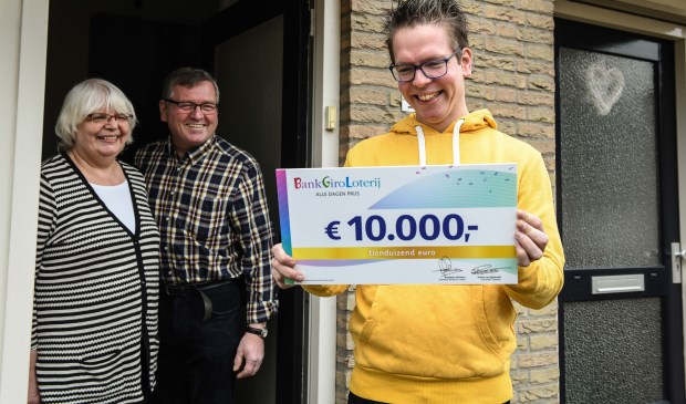 Gert Jan uit Geffen ontvangt, in het bijzijn van zijn ouders, een cheque van 10.000 euro van de BankGiro Loterij.