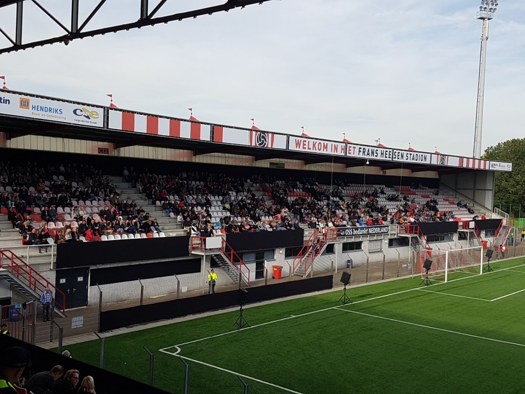 Mensen tijdens de herdenking in het stadion van TOP Oss.