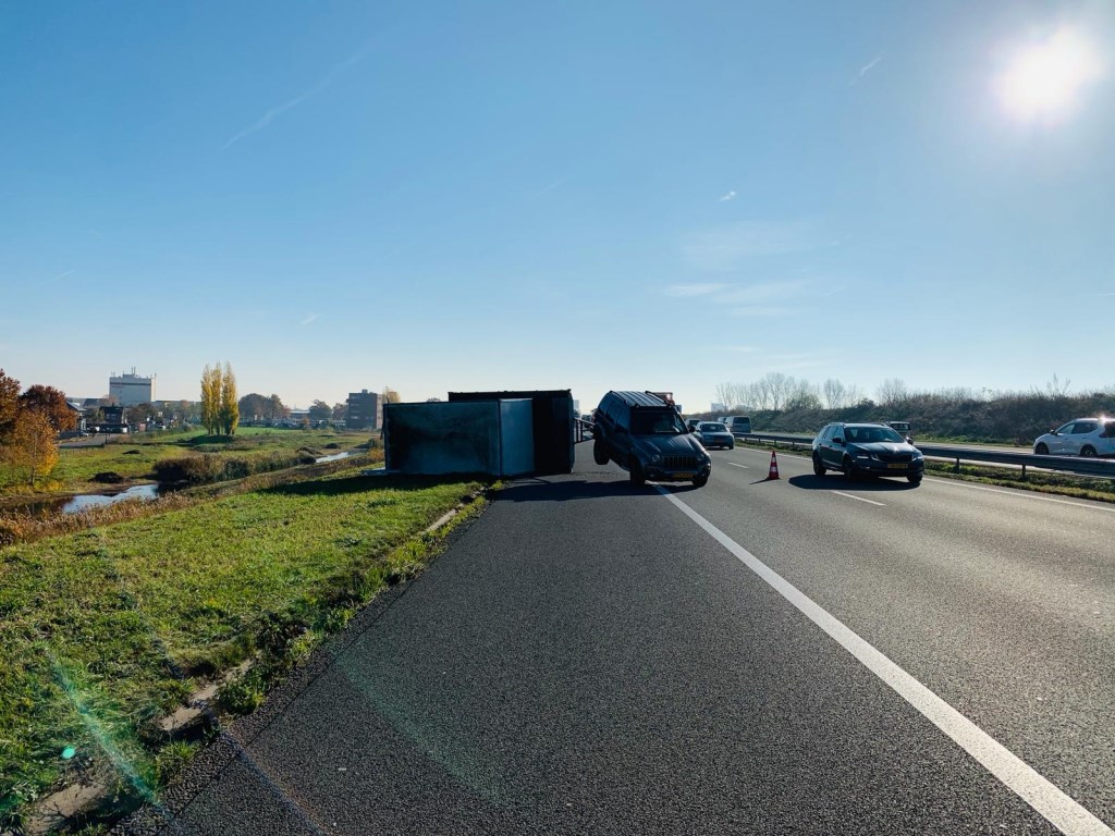 Jeep met aanhanger op zijn kop.