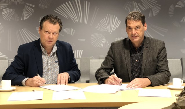 Eus Witlox en Jan van Vucht ondertekenen de contracten.