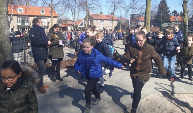 Kinderen rennen rondom de school