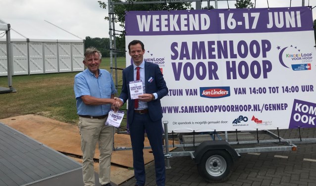 Vestigingsmanager Jacco Dijkema (rechts) neemt de eerste programmaboekjes in ontvangst van SamenLoop Gennep voorzitter Teus van Leeuwen voor het terrein waar het komend weekend allemaal gaat gebeuren.