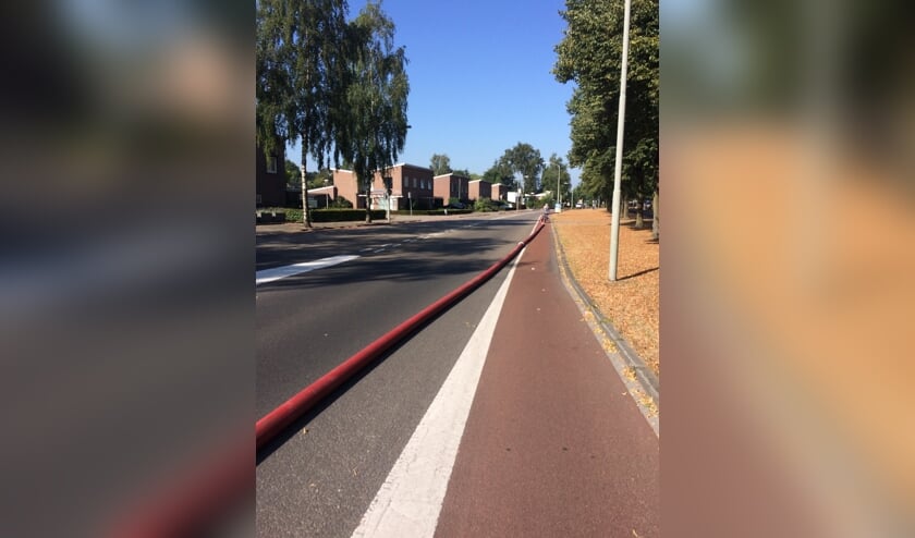 De brandslang die over de weg lag