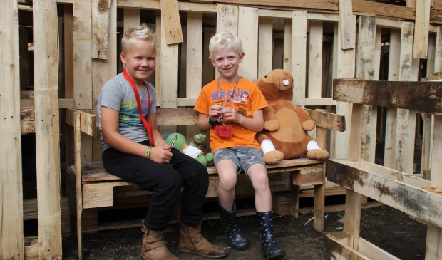 Pim (7) en Jens (6) zitten even op een bankje bij te praten.