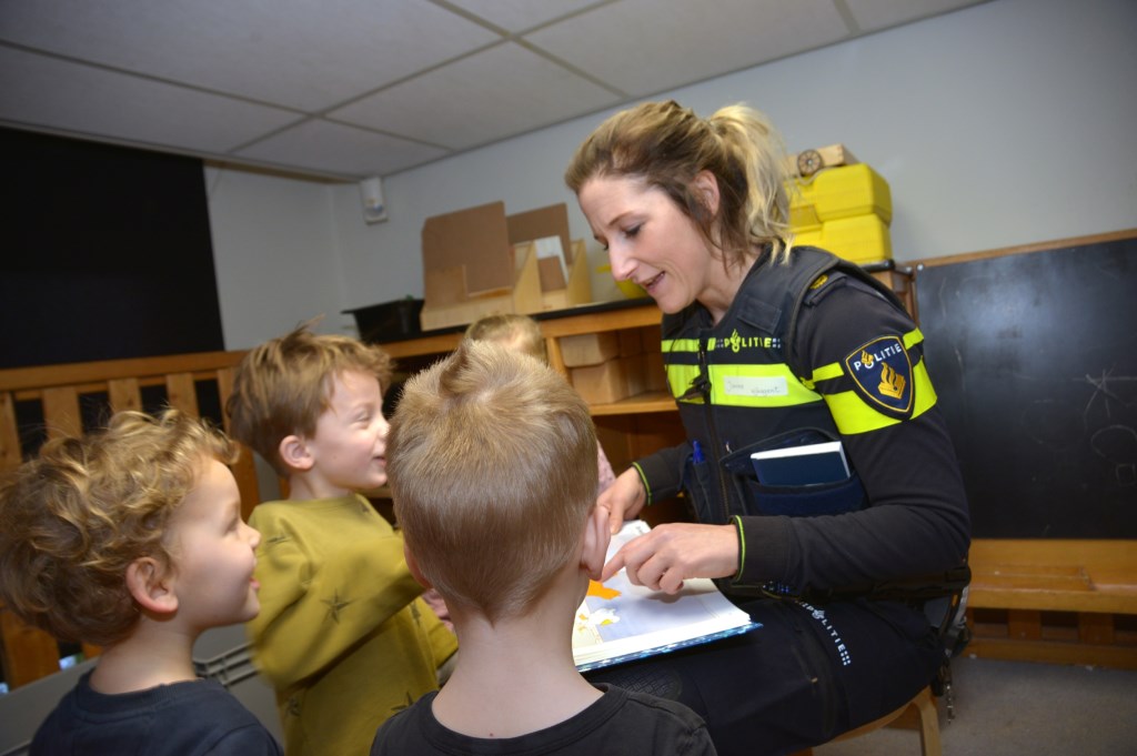 Met lachende gezichtjes luisteren de kinderen naar de wijkagente