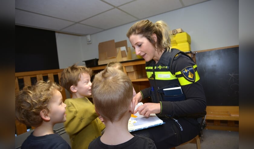 Met lachende gezichtjes luisteren de kinderen naar de wijkagente