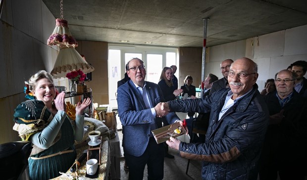 Wethouder Van den Bogaard (L) overhandigt aan een toekomstige bewoner de 'huissleutel'.