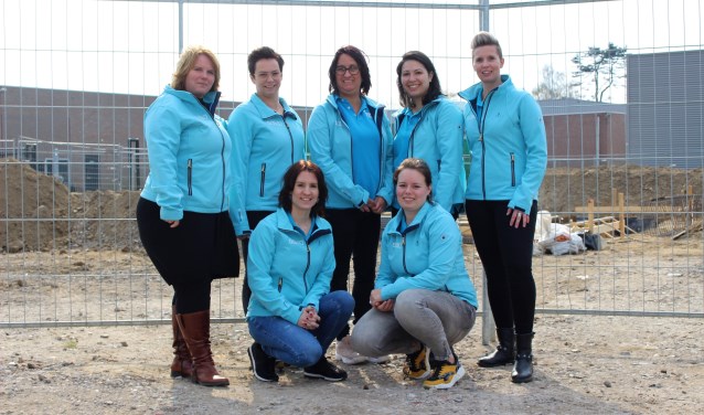 Medewerkers van Eerste Klas poseren voor de bouwplaats.