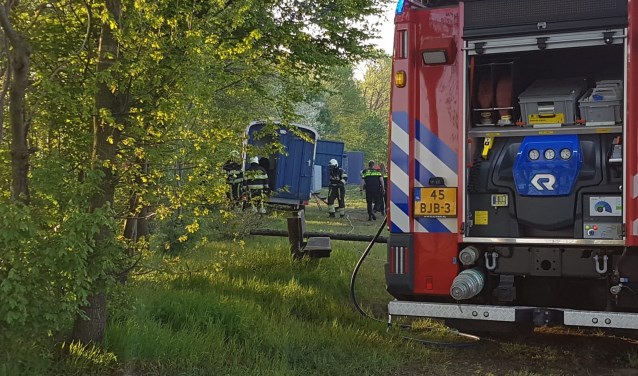 De brandweer blust de brand in de keet