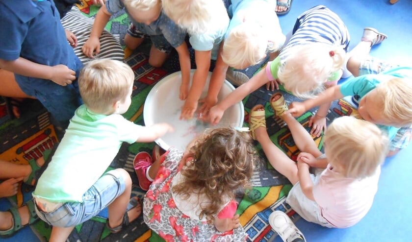 De peutergroep wast de kleertjes van pop Puk bij Kinderopvang De Dag Door in Boxmeer.