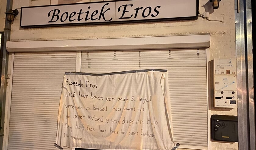 Man hangt spandoek op bij Boetiek Eros - Kliknieuws.nl