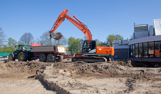 Tractoren rijden af en aan om de grond af te voeren