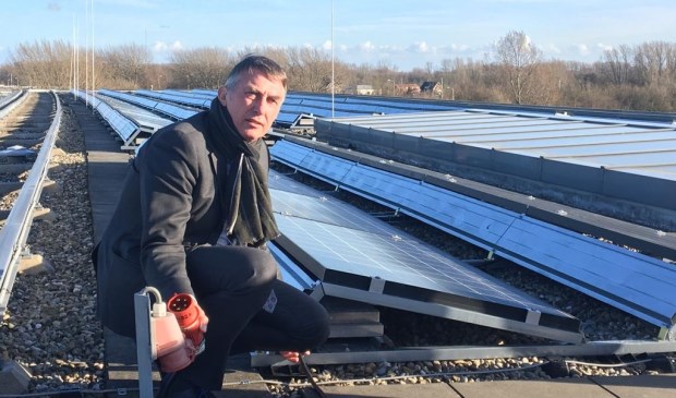Wethouder Abee bij de zonnepanelen op het dak van het gemeentekantoor.