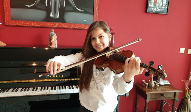 Adinda met haar viool in de huiskamer.