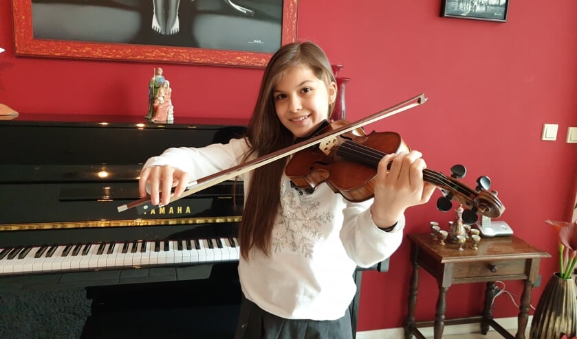 Adinda met haar viool in de huiskamer.