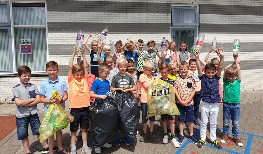 Leerlingen van CBS De Acker tonen trots hun lege flessen.