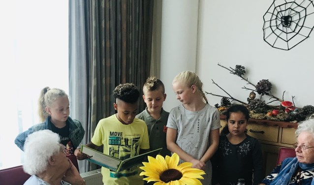 De leerlingen lazen voor aan ouderen.