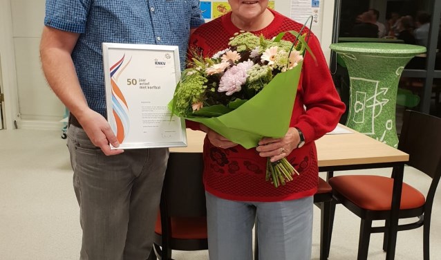 Bloemen, een oorkonde en een speld voor Sijtje Groeneveld.