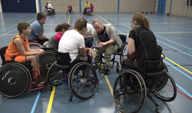 Met tablet legt Mitchell het strijdplan voor de wedstrijd uit.