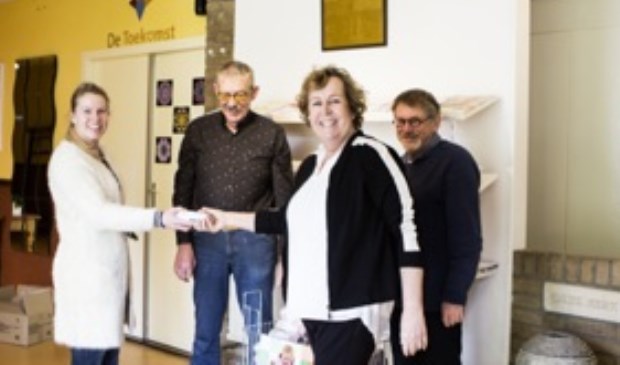 Foto: Michelle Olieman. Cristina van der Mijden-Schutte van Bar-Afvalbeheer overhandigt aan Betty Guijs van St. de Toekomst en enkele leden van de PG Bolnes de draadmand met de rollen PMD zakken.