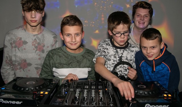 De jongeren poseren trots achter de professionele dj set.