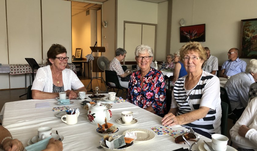 De dames genieten van de high tea en elkaars gezelschap.