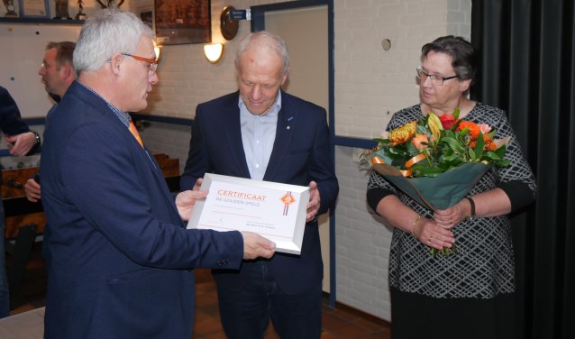 Henk ontvangt het certificaat behorende bij de gouden speld uit handen van Toon Kerkhof, met naast hem zijn vrouw Marieke | Fotonummer: 23e2da