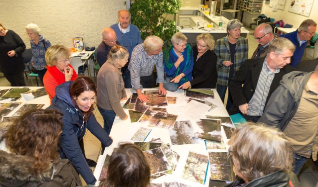 Beheerders van het groen en bewoners bogen zich over de foto's van het gewraakte gebied langs de houtwallen in Haaswijk. | Foto Wil van Elk