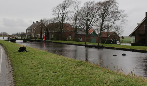Twee wielen van de sportwagen steken nog net boven het water uit.
