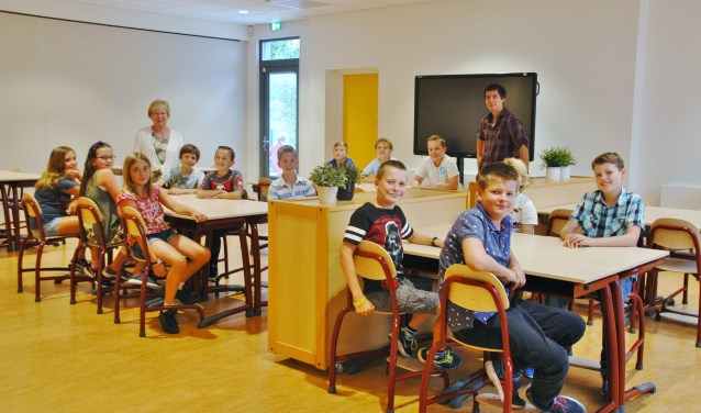 Groep 8 van de Regenboog in de fonkelnieuwe aula. Linksachteraan staat locatieleider Carla Kerner.