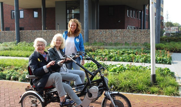 Annechien Snuif krijgt uitleg van een andere duofiets-vrijwilliger. Ada Seijsener (l) geniet volop.