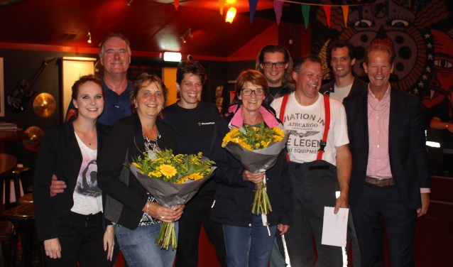 De vrouwen van de jubilerende brandweermannen krijgen de bloemen in handen. | Foto: Annemiek Cornelissen