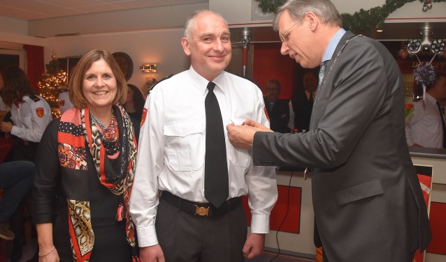 Burgemeester Visser speldt de koninklijke onderscheiding op bij André Jonker.