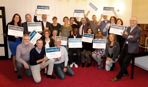 Voorzitter Rob van Vreedendaal (rechts) heeft zojuist aan alle 13 organisaties hun cheque overhandigd en die zijn er blij mee.