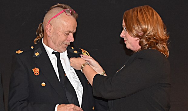 Ron Hoogeboom krijgt de koninklijke onderscheiding opgespeld door burgemeester Carla Breuer. | Foto: Piet van Kampen