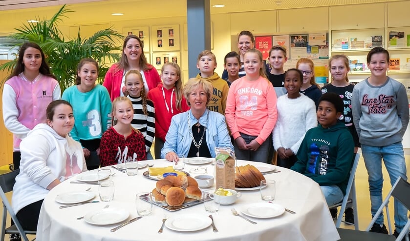 Groep 8 van 't Bolwerk en burgemeester Driessen vlak voor ze aan hun gezonde ontbijt beginnen.