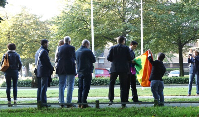 Raadsleden en COC-leden bij het hijsen van de regenboogvlag in de mast tegenover het gemeentehuis.
