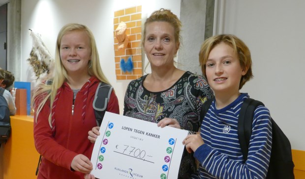 Jazahra Vogel en Storm Ligtvoet overhandigen Corina van Diest van ‘Lopen tegen Kanker’ symbolisch de cheque met het bij elkaar gelopen bedrag. | Foto: pr.
