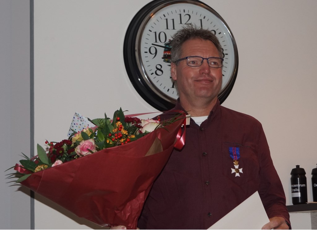 Christian van der Klauw met bloemen en oorkonde.