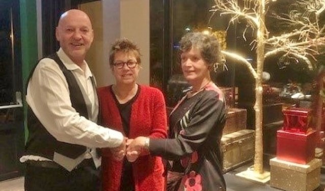 Voorzitter van het district Renée Lucas, midden, drukt de hand van voorzitter Frans van Rijn en secretaris Petra Montagne van de afdeling Duin en Bollenstreek Rode Kruis.