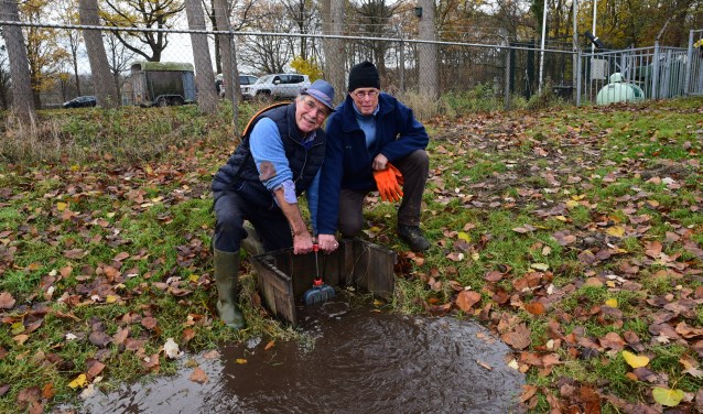 Cees Juffermans en Jan Mulder draaien gezamenlijk de inlaat van de ijsbaan open.