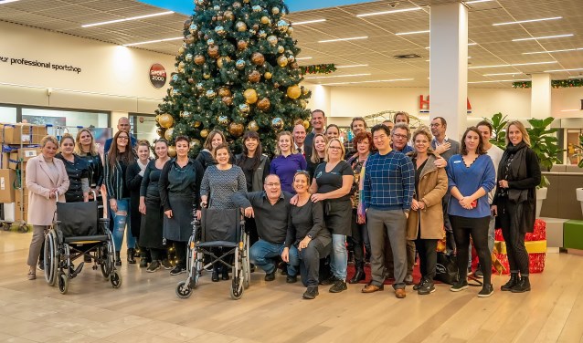 Ook de winkeliers staan achter het plan voor een rolstoeluitleen in Winkelhof. Een groot aantal van hen ging vorige week met Annelies Hoedt (geheel links) en Mariette Meulman (achter rechter rolstoel) op de foto als teken van steun. De beoogde rolstoelen zien er overigens niet zo uit als die op de foto. | Foto: J.P. Kranenburg