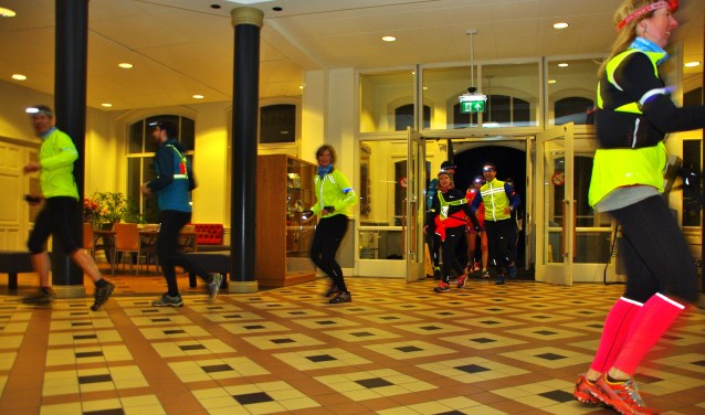 Deelnemers aan de eerste Oegstgeester nighttrail rennen door het gemeentehuis. | Foto Willemien Timmers