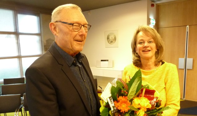 Joop Zwetsloot, de maker van het nieuwe filmpje, krijgt van Lies Spruit een bos bloemen als dank.