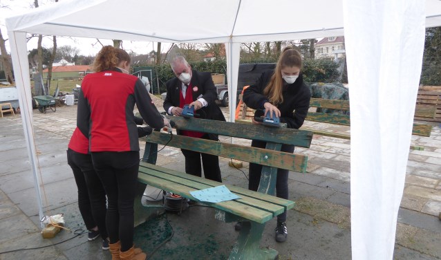 Medewerkers van de Dirk pakten de oude bankjes aan voor een nieuwe verflaag. | Foto: Ina Verblaauw