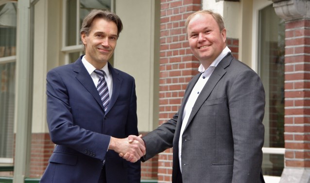 Fractievoorzitter Sven Spaargaren schudt Marcus Rolloos (r) de hand, die met 164 voorkeurstemmen opnieuw een zetel in de gemeenteraad heeft weten te veroveren. | Foto Willemien Timmers