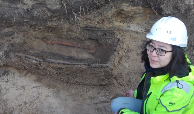 Archeologe Minja Hemminga bij de enige grafkist die de eeuwen in de 'verwoestende' zandgrond heeft getrotseerd. | Foto: Piet de Boer