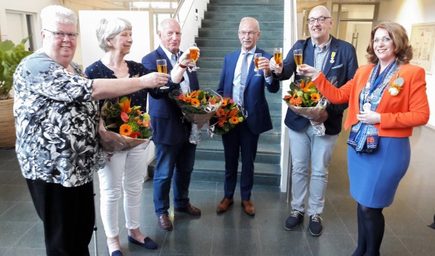 De vijf gedecoreerden, Nel Berg – van Kampen, Els Alewijnse – de Groot, Hans van Rooijen, Ton Oostdam en Willem Vogels, heffen het glas met burgemeester Carla Breuer. Rob de Graaff kon door omstandigheden niet aanwezig zijn. | Foto: MV